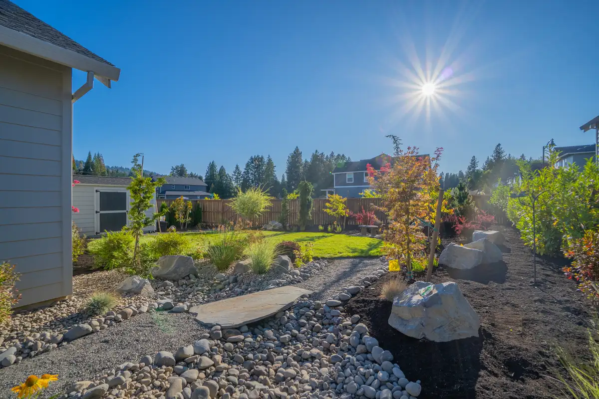 Dry creek bed with sun starburst by CreekView Landscape