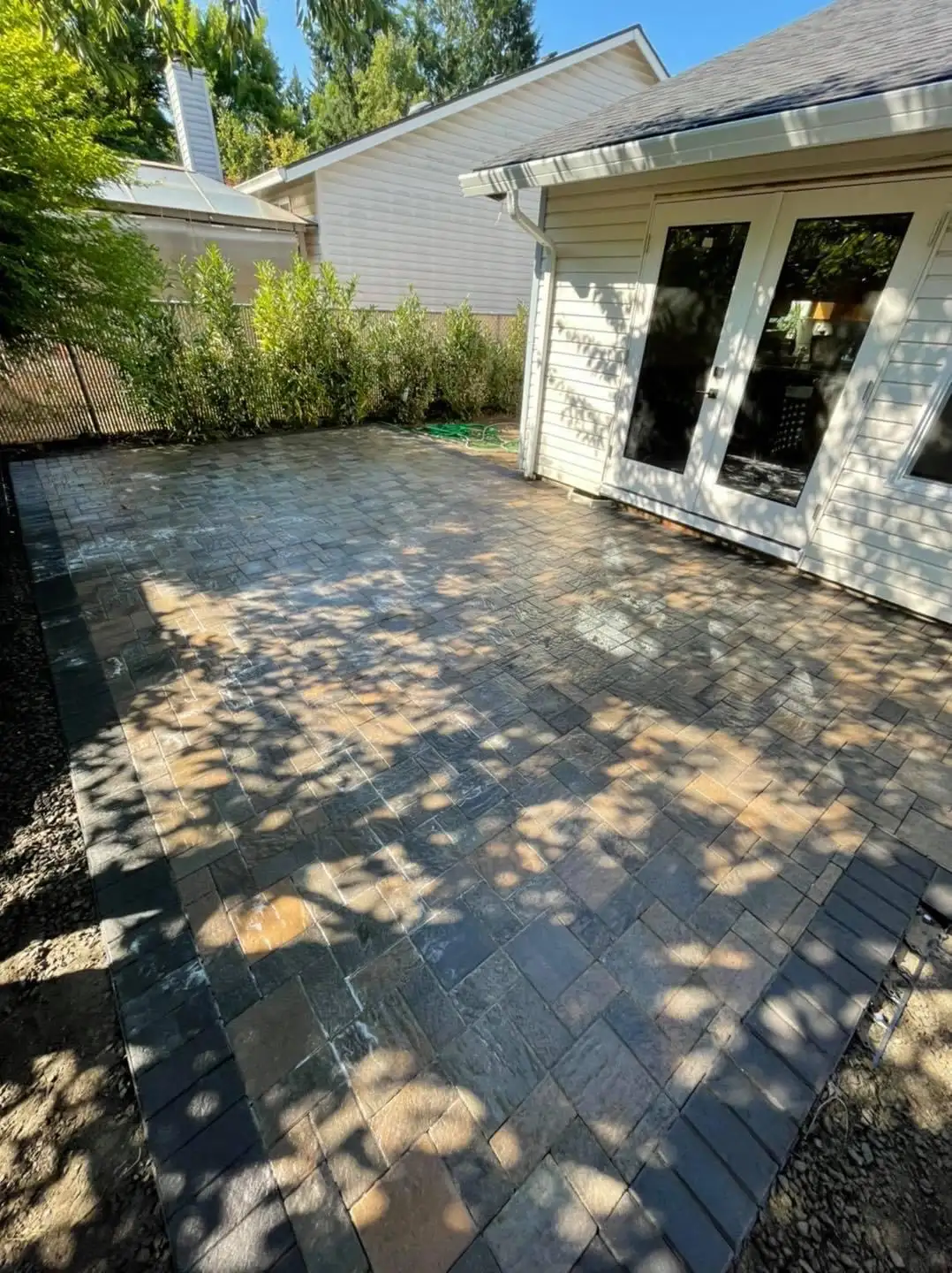 Expansive natural stone-look paver patio by CreekView Landscape in Oregon