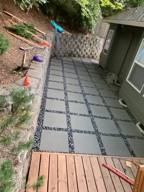 Square paver patio with river rock border by CreekView Landscape