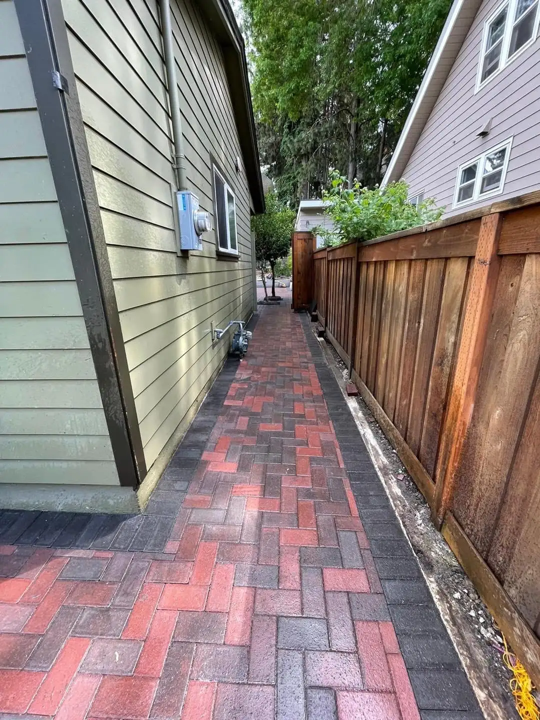 Block retaining wall with steps going up hillside by CreekView Landscape in Oregon