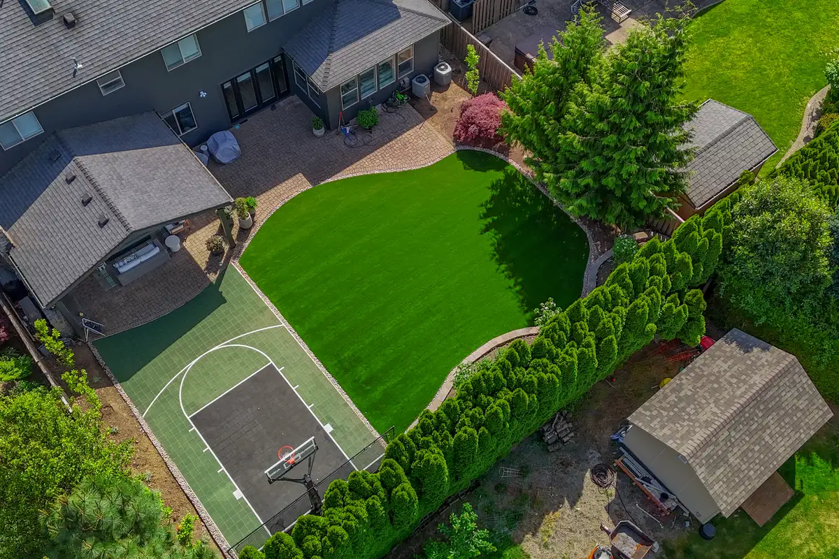 Aerial drone view of complete backyard remodel with turf by CreekView Landscape